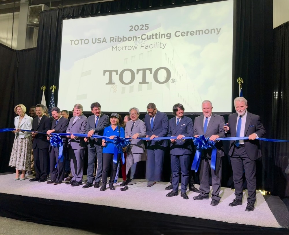 Group of executives pose for ribbon cutting at new TOTO plant