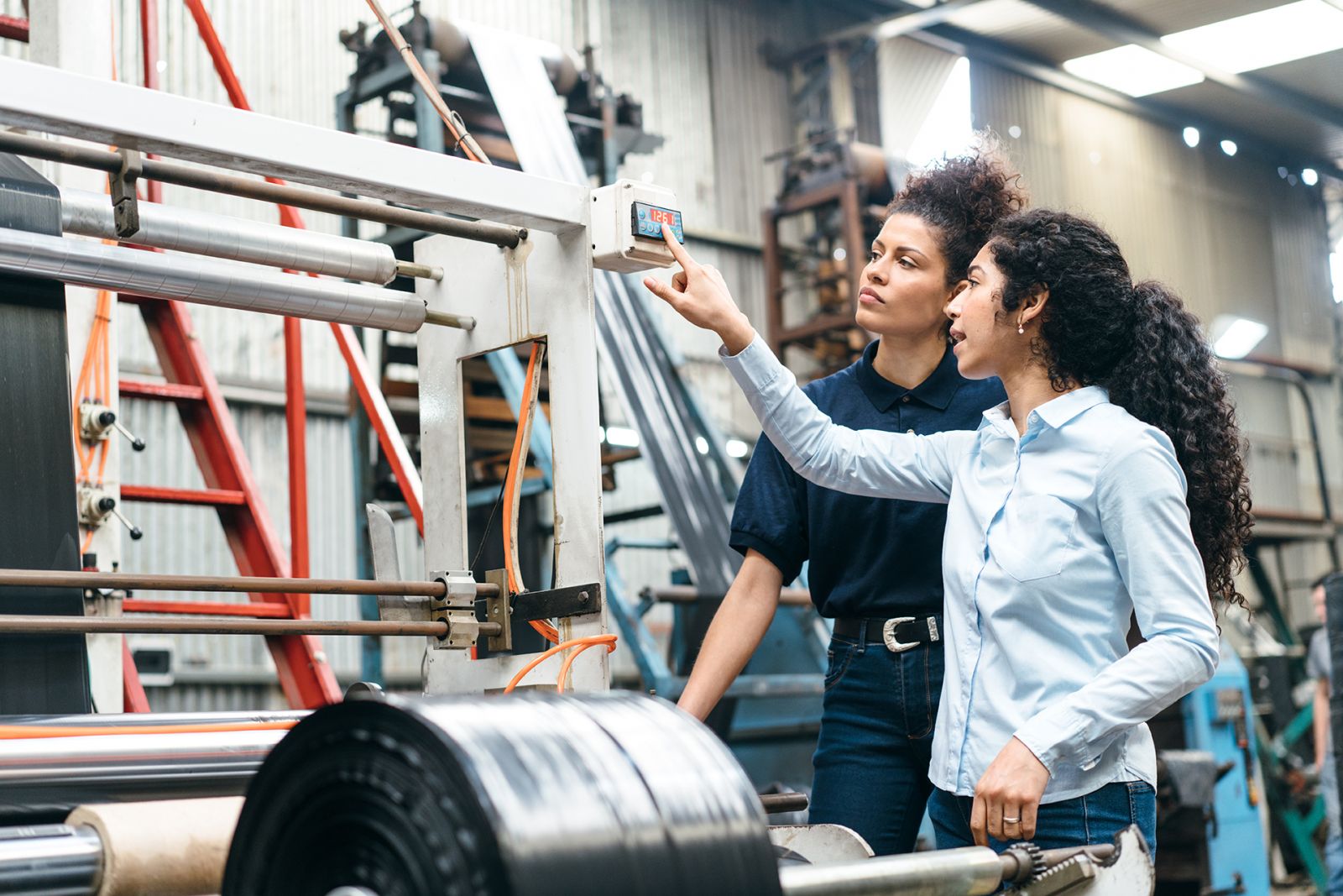 factory workers pointing to machinery
